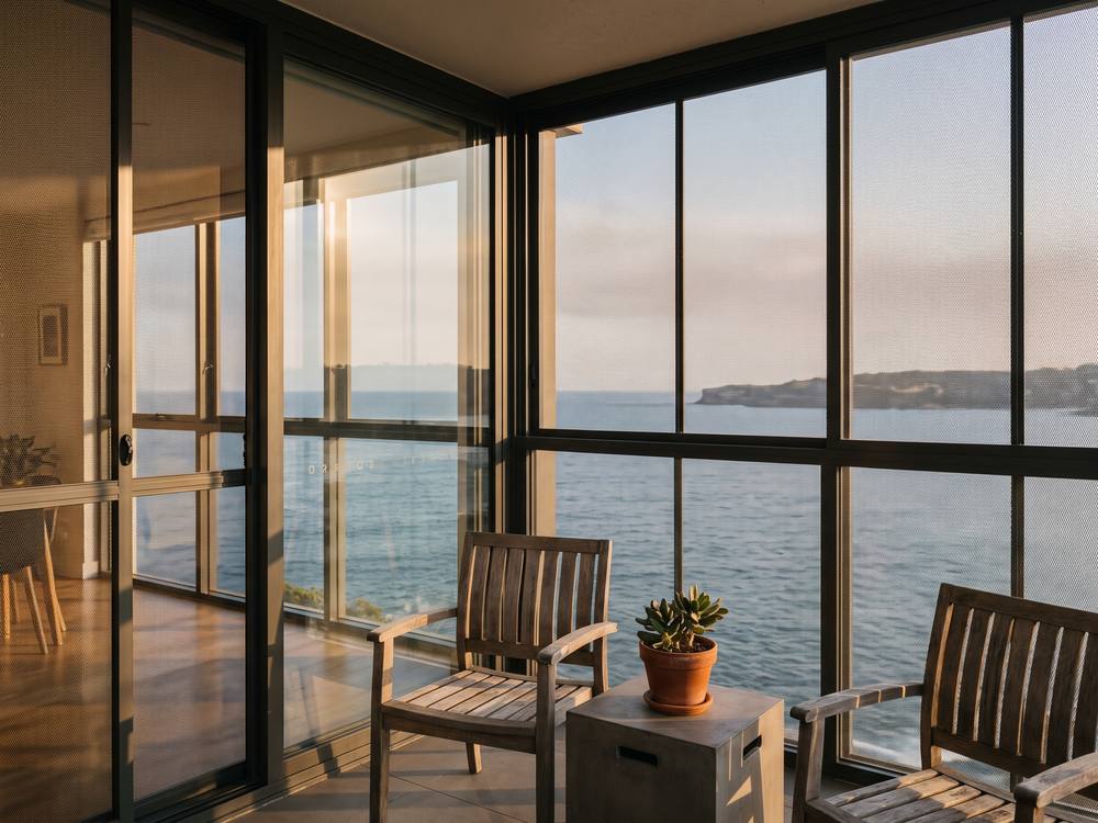Coastal Sydney balcony fully enclosed with security screens, ocean view unobstructed